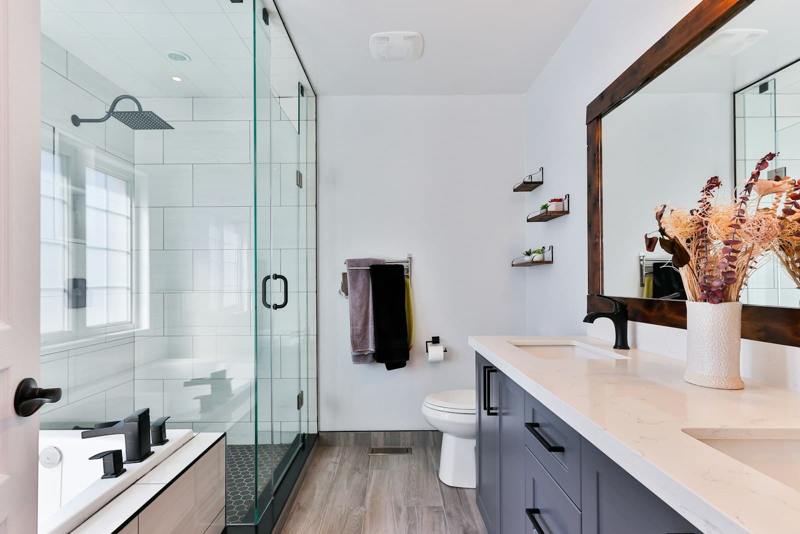Finished bathroom with a glass shower, soaking tub, and double vanity