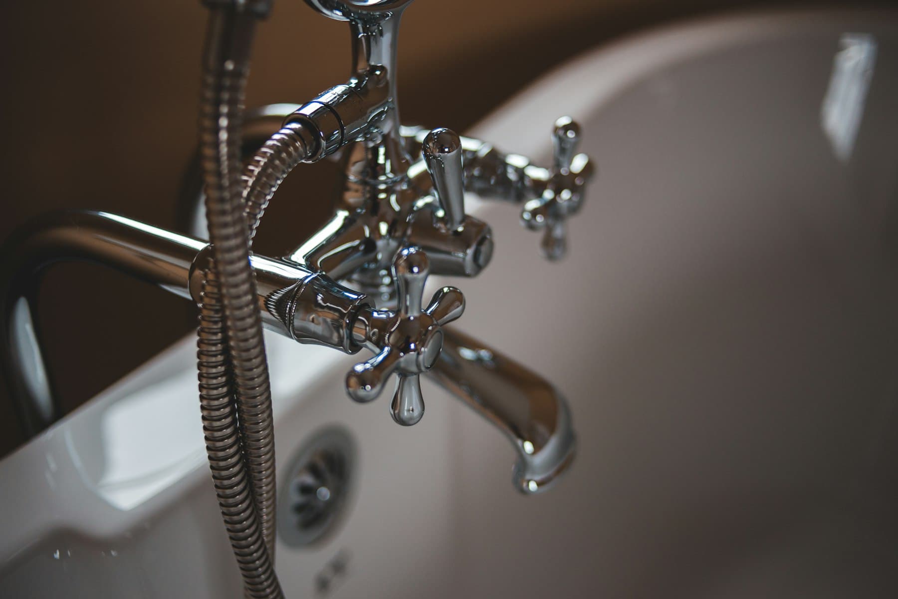 Chrome tub filler and handheld sprayer on a white bathtub